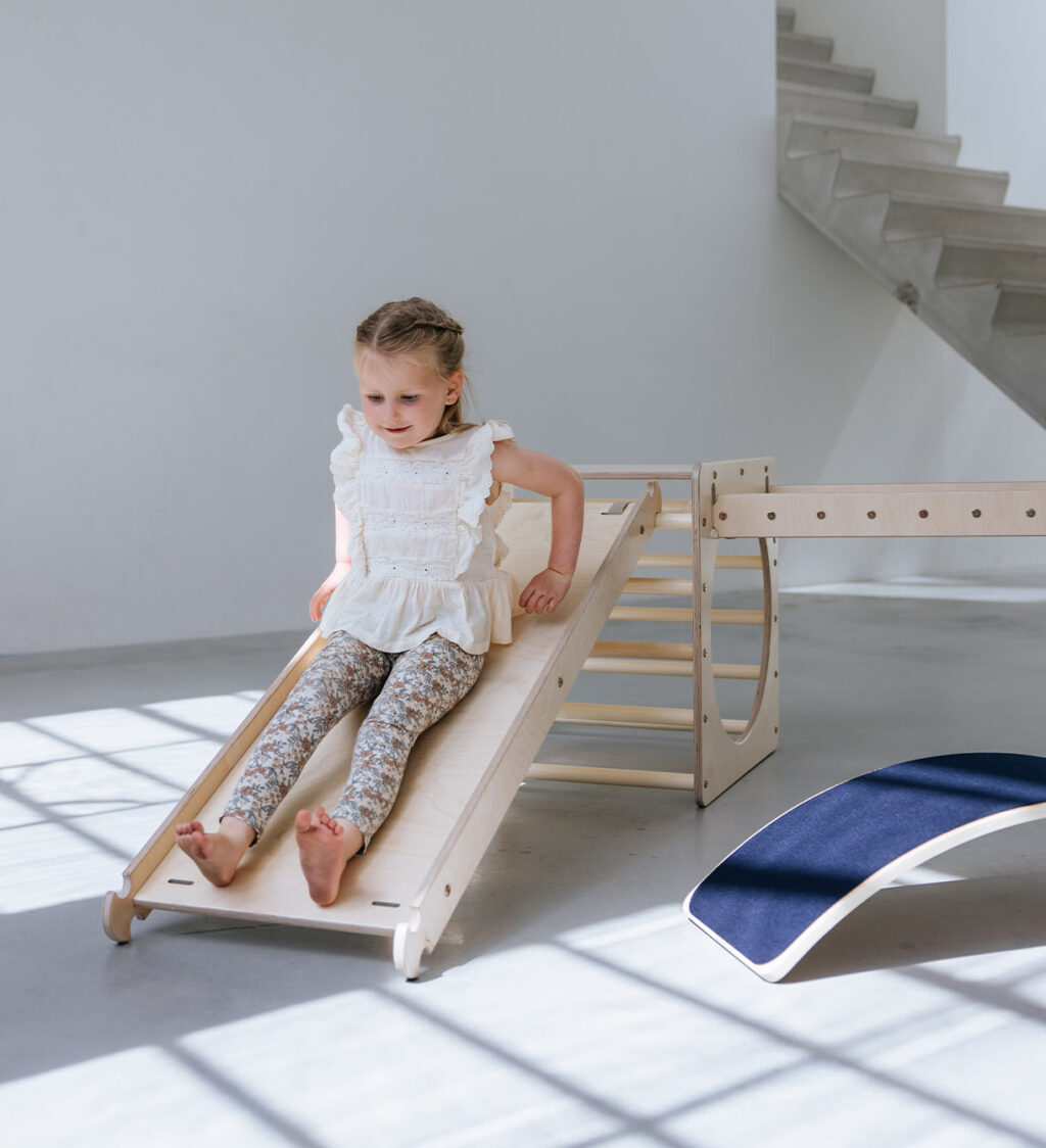 Houten glijbaan met klimrek binnen