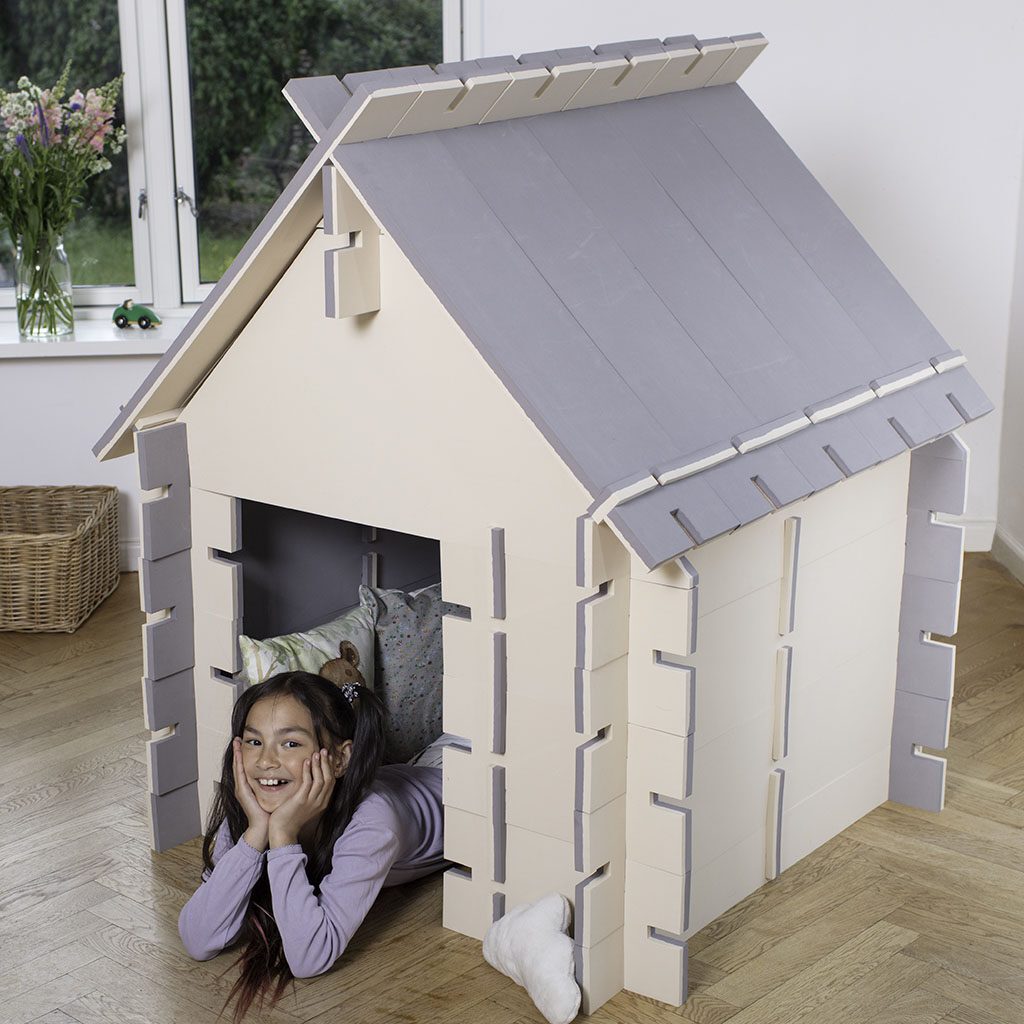 Speelhuisje in woonkamer met blij kind