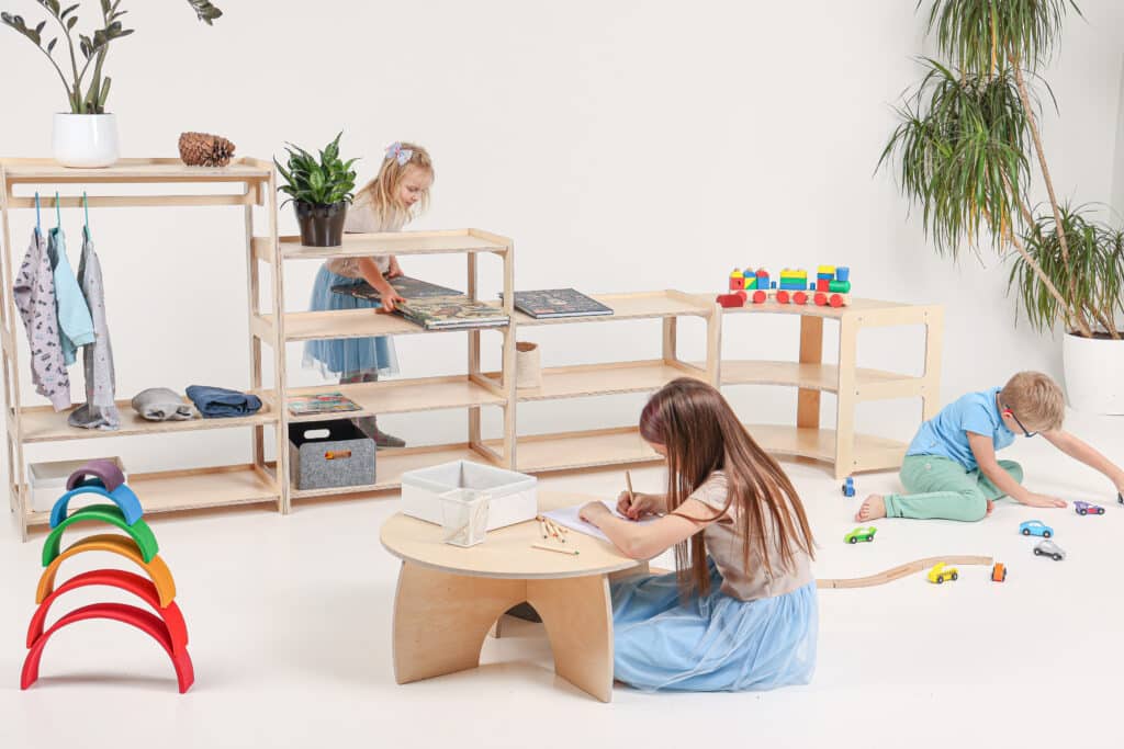 Spelen aan montessori tafel met speelgoedkasten