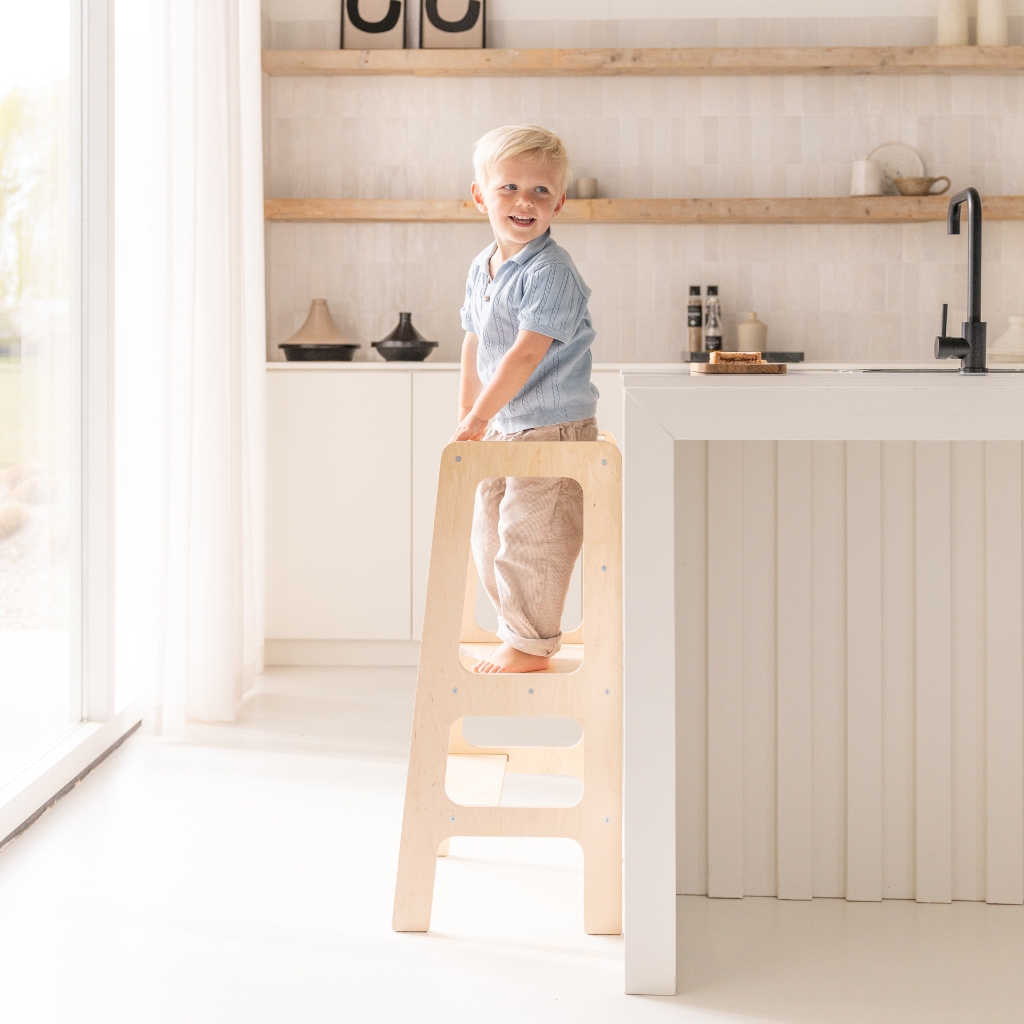 Omgedraaid staan op Montessori leertoren kijken naar buiten