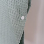 Badcape | poncho Jindl lichtgroen detail drukknoop