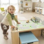 Betzold tapijt voor een speeltafel op de vloer - set van 2 - jongentje leunend op speeltafel met tapijt van de stad en auto's