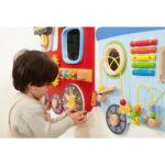 Trein wandspel - jongentje spelend met de wielen van de eerste (rode) trein
